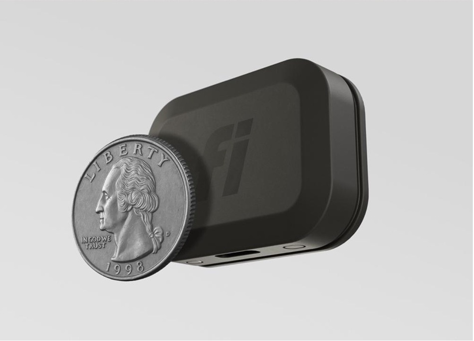 Fi Mini tracker beside a quarter to show its compact size