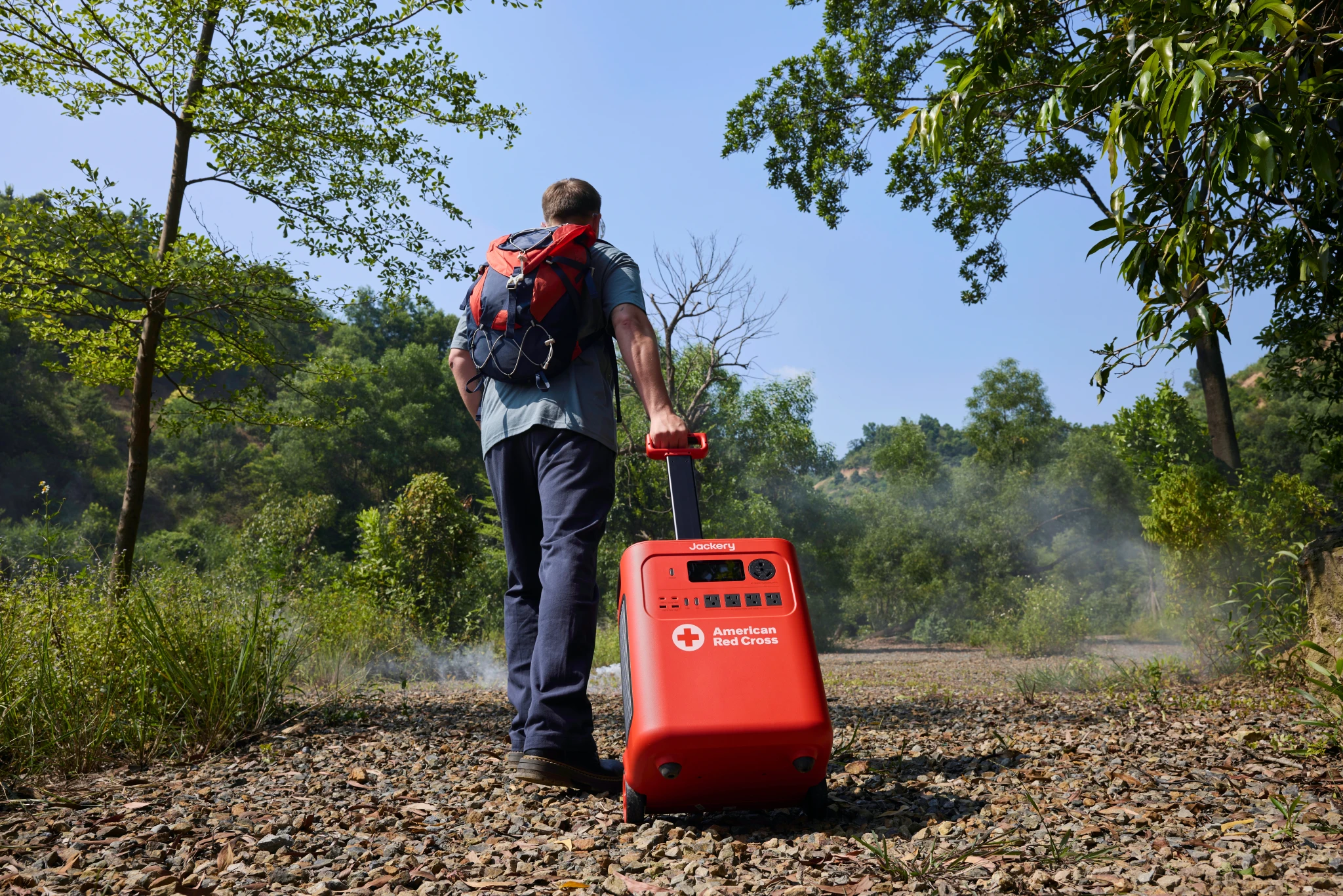 Jackery Red Cross Edition power station being wheeled along an outdoor trail