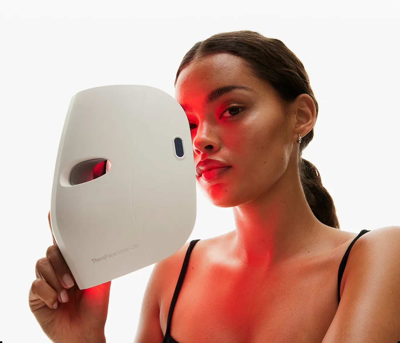 Therabody LED beauty mask held beside the face
